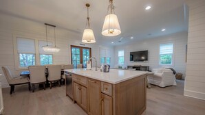 A spacious kitchen with a large island, wooden cabinets, and pendant lighting. - 4 BR Grayton Beach, private beach, Tesla charger, 2 pools, tennis, & Pickle ball (Santa Rosa Beach)