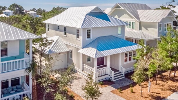 Un quartier résidentiel composé de plusieurs maisons dotées de toits à pignons et d’une maison centrale avec un toit bleu.