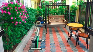 A patio with a wooden bench, a bicycle, and a small table. - Arina Boutique Kampot (Kampot)