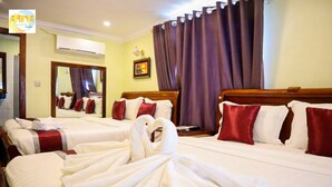 A hotel room with two beds, each with white linens and red pillows. There is a large mirror on the wall, a picture frame, and a window with purple curtains. - Arina Boutique Kampot (Kampot)