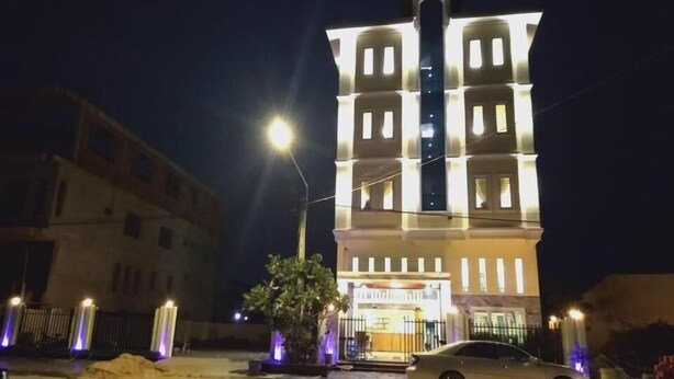 A multi-story building with illuminated windows and a central tower. - Arina Boutique Kampot (Kampot)