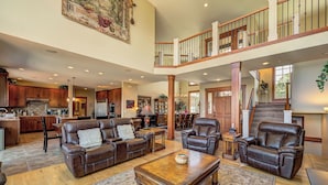 A spacious living area with a high ceiling, a dining area, and a kitchen. - Riverview Retreat: Incredible Views, Heated Pool, Spa, Theater Room & More! (East Wenatchee)