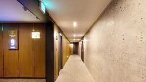 Un pasillo de hotel con paneles de madera, un letrero de zona VIP y un cartel con el número de piso.