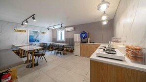 Una cocina moderna con encimeras de mármol, horno empotrado y cafetera.