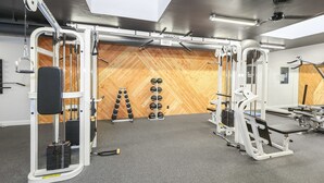 A gym with various exercise equipment, a wooden wall, and a ceiling with a skylight. - F110-Sea Pointe, North Coast Village 2 queen bdrm (Oceanside)