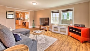 A living room with a gray sofa, a coffee table, a TV, and a red entertainment unit.