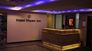 A reception area at Hotel Shyam Inn with a reception desk and a chandelier. - Hotel Shyam Inn (Bengaluru)