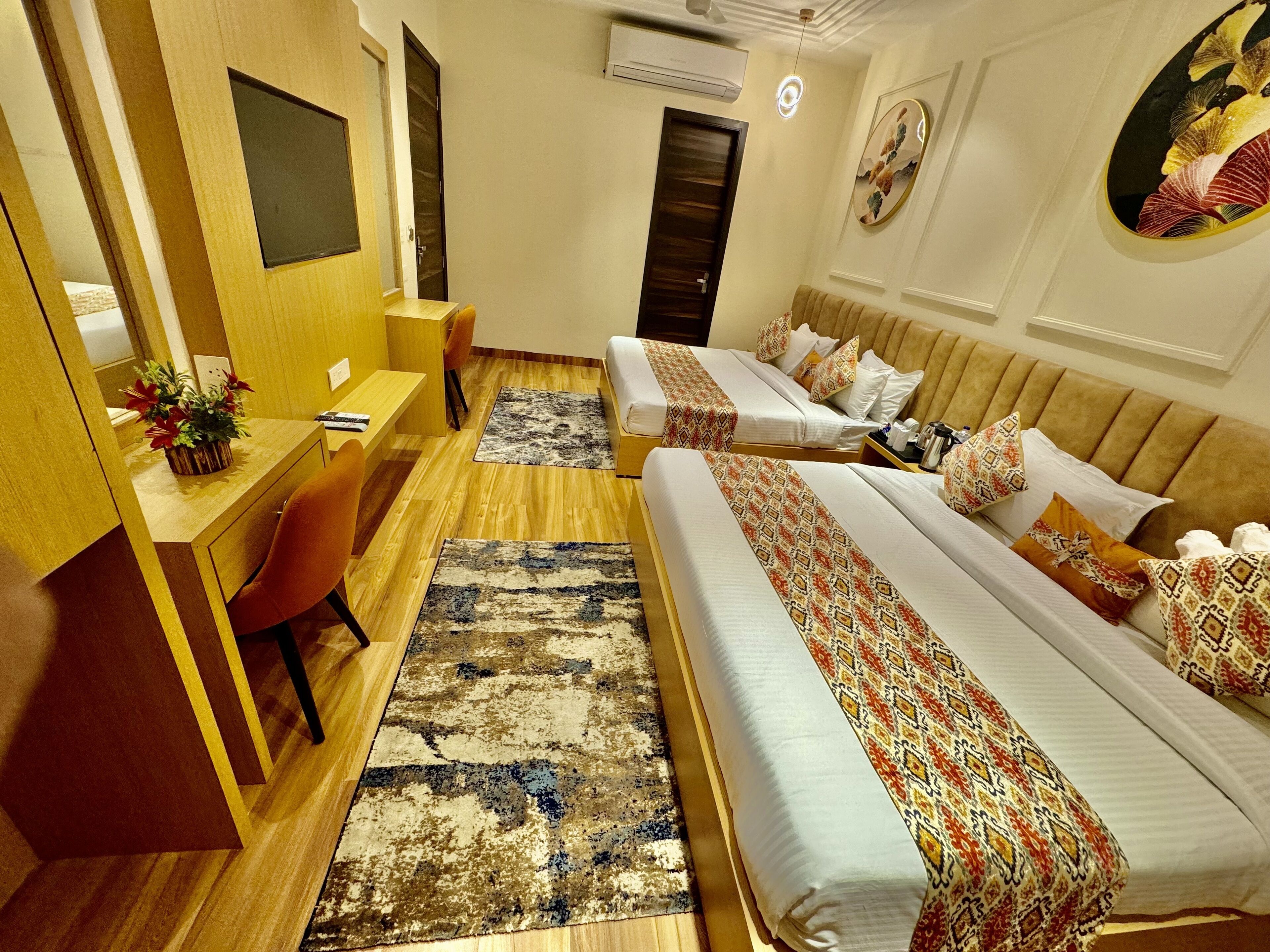Habitación de hotel con dos camas, un escritorio, una silla y una mesita.