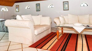 A cozy living room with two cream-colored sofas, a glass coffee table, and a red and beige striped rug. - 6 Person Holiday Home in Hojer (Højer)