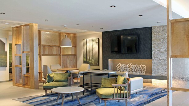 A modern living room with a sofa set, a coffee table, and a TV mounted on the wall.