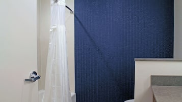 A bathroom with a shower curtain, a toilet, and a sink.