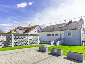 Un edificio moderno con una escalera, un área pavimentada y un letrero que dice 'Alexander'.