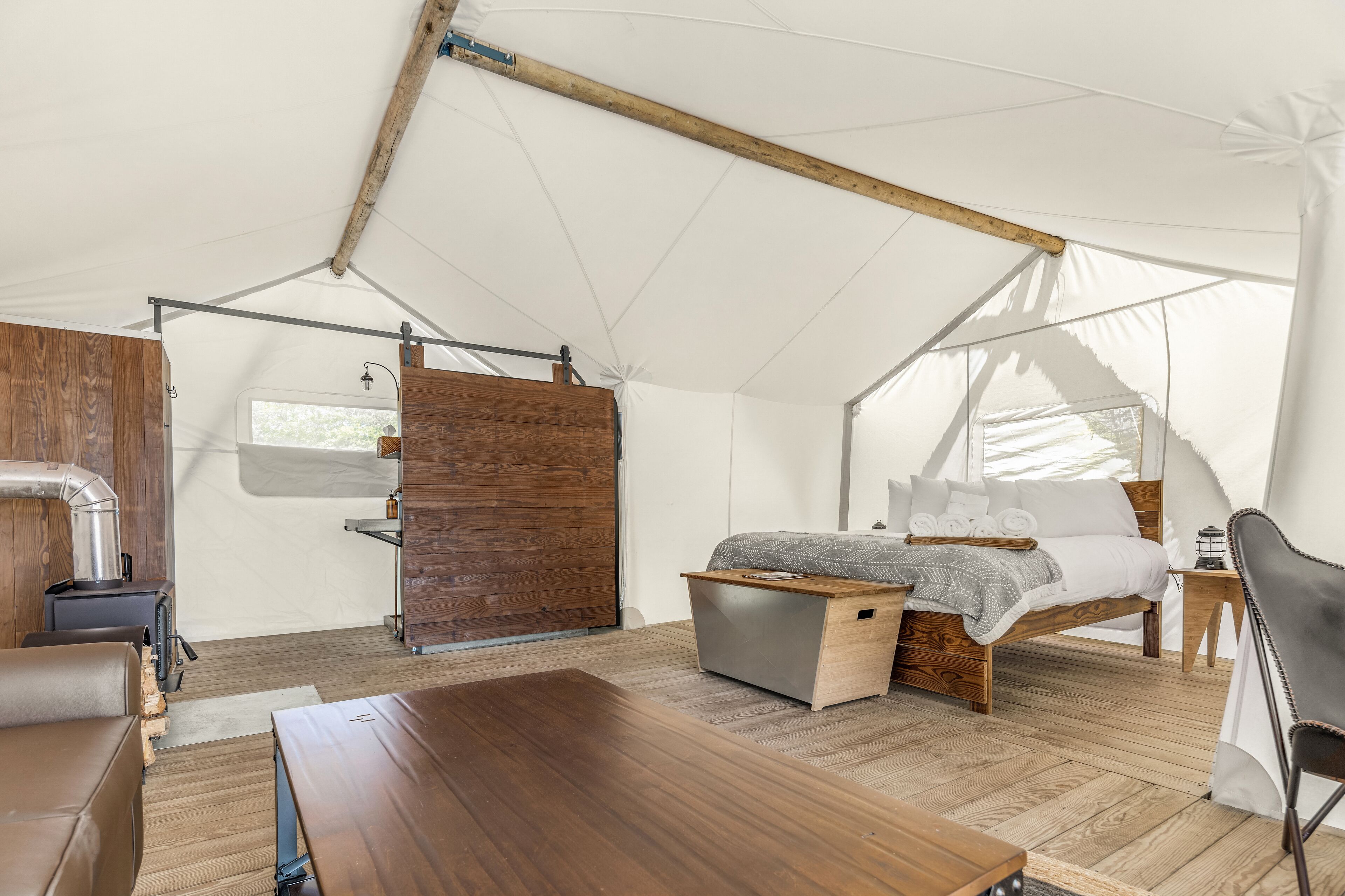 Una tienda de campaña con una cama, una mesa y una silla.