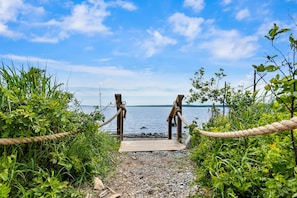 A wooden pathway leading to a wooden structure by a body of water.