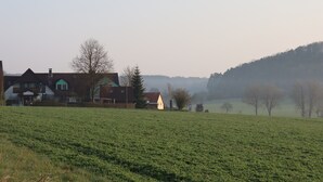 A rural landscape with houses and a green field. - Gasthof Zur Altmühlquelle (Windelsbach)