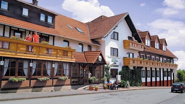 A row of traditional European-style buildings with multiple stories, featuring balconies with plants and outdoor seating areas. - Hotel Zur Igelstadt (Lichtenfels)