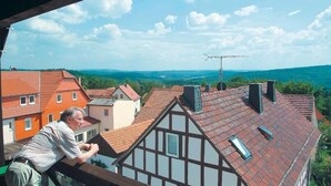 A view from a balcony overlooking a town with traditional half-timbered houses and a clear sky. - Hotel Zur Igelstadt (Lichtenfels)