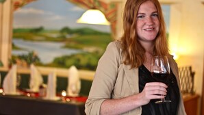 A person holding a wine glass in a room with a painting of a landscape on the wall. - Hotel Zur Igelstadt (Lichtenfels)