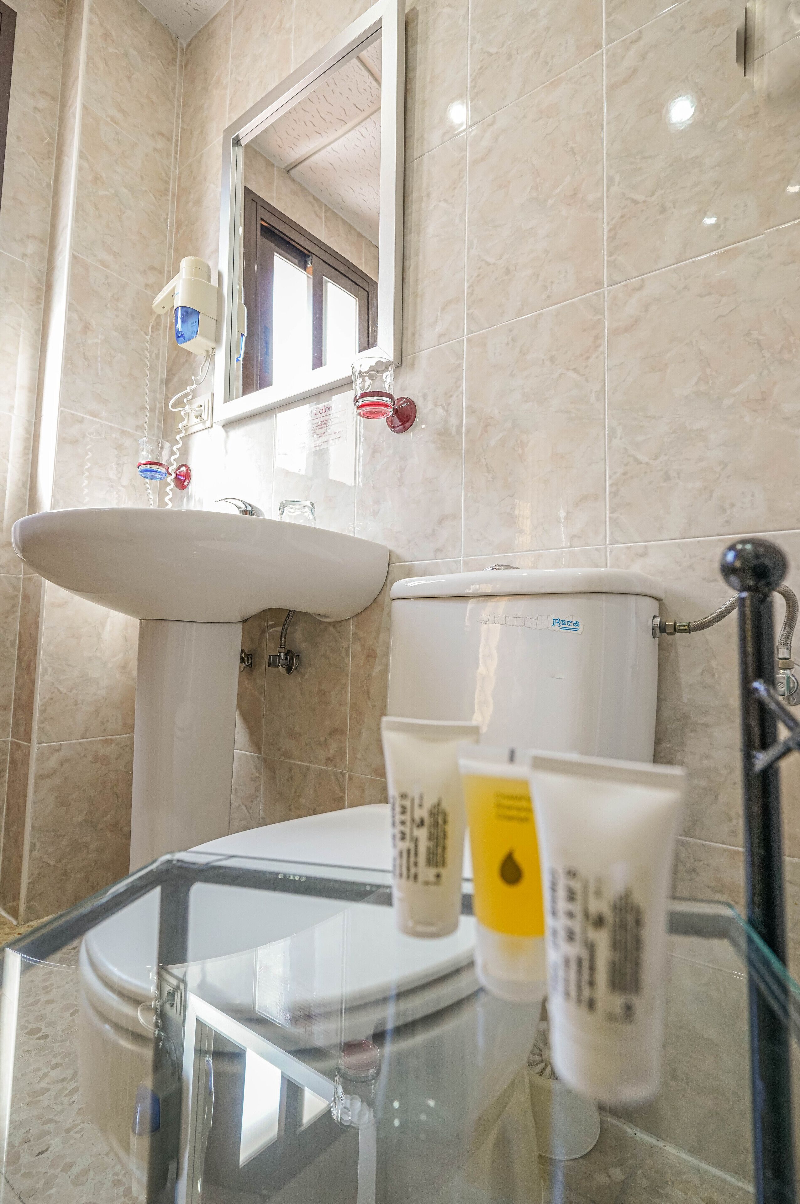 A bathroom with a white sink, a toilet, and a glass shower enclosure.