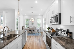 Enjoy cooking in this well-lit kitchen with a central island, sink, range, and microwave.