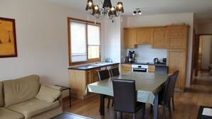 A compact living space with a kitchenette, dining area, and a sofa.