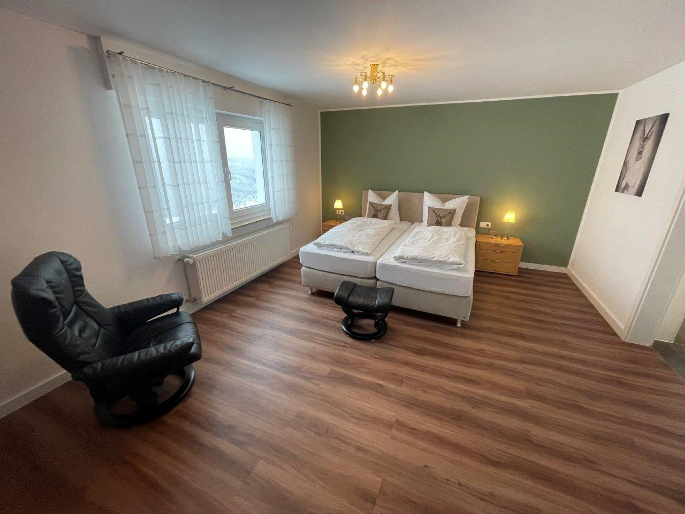 Une chambre avec deux lits, une chaise, un radiateur et une fenêtre avec des rideaux.