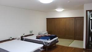 Habitació amb dos llits, un armari de fusta i un futón.