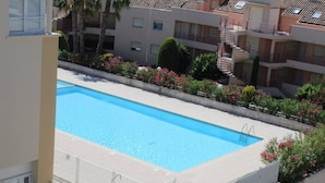 En rektangulär swimmingpool med ett metallstaket som fungerar som säkerhetsbarriär, omgiven av en betongplattform.