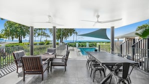 En uteplats med pool, sittplatser och utsikt över havet.