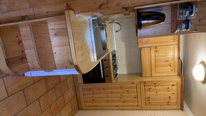 Une cuisine avec des meubles de rangement en bois, un plan de travail et un évier.