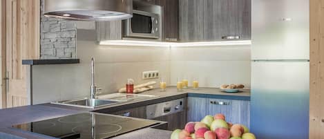 Une cuisine moderne équipée d’une cuisinière intégrée, d’un four à micro-ondes et d’un réfrigérateur.