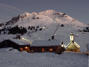 Surrounded by snow-covered mountains, this rustic cabin offers a warm and inviting atmosphere.