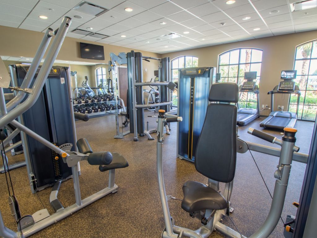 A gym with various exercise machines, weight benches, and dumbbells.