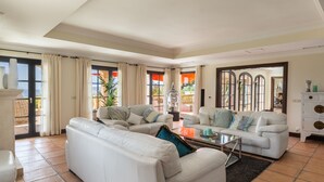 Un salón amplio con un sofá grande, una mesa de centro y vistas al exterior.