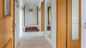 A hallway with wooden doors, a red and white rug, and framed pictures on the walls. - Holiday Apartment "Munding" with Garden, Terrace, Lake View, Grill & SAT-TV (Überlingen)