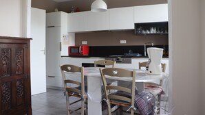 A kitchen with white cabinets, a red microwave, and a coffee maker. - L'havre zen cancalais - Apart peaceful 4 pers tt confort (Cancale)