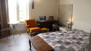 A bedroom with a bed, a desk, a chair, a small table, and a window. - L'havre zen cancalais - Apart peaceful 4 pers tt confort (Cancale)