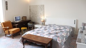 A bedroom with a bed, a chair, a desk, a lamp, and a television. - L'havre zen cancalais - Apart peaceful 4 pers tt confort (Cancale)