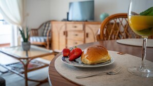 Een eettafel met een bord eten, een glas drinken en een stoel.