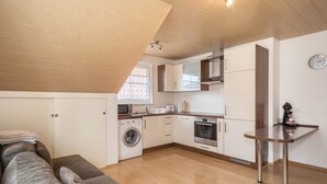 Una cocina compacta equipada con lavadora, horno y microondas.