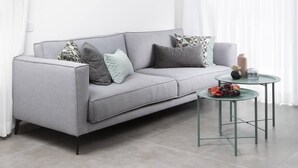 A modern living room with a grey sofa, a glass coffee table, and a round ceiling light. - Chic Sea View Balcony Escape by Sea N' Rent (Nahariya)