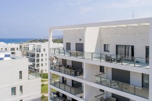A multi-story building with balconies, large windows, and a view of the sea. - Chic Sea View Balcony Escape by Sea N' Rent (Nahariya)