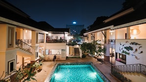 A courtyard with a swimming pool, multiple balconies, and a staircase leading to the upper floors.