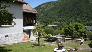 A house with a white exterior, a wooden roof, and a stone staircase leading to the entrance. - House with large, quiet garden and beautiful mountain views (ANTIGNAC)