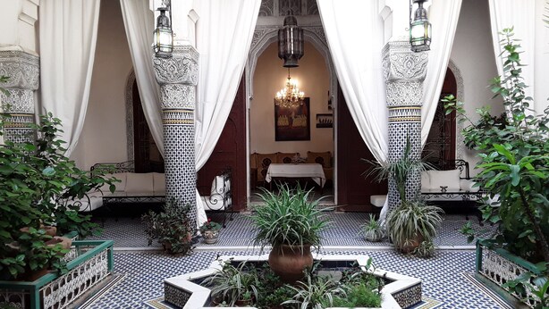A courtyard with a fountain, patterned tiles, and ornate columns. - Riad Vega. A haven of peace in the heart of the medina (Fès)