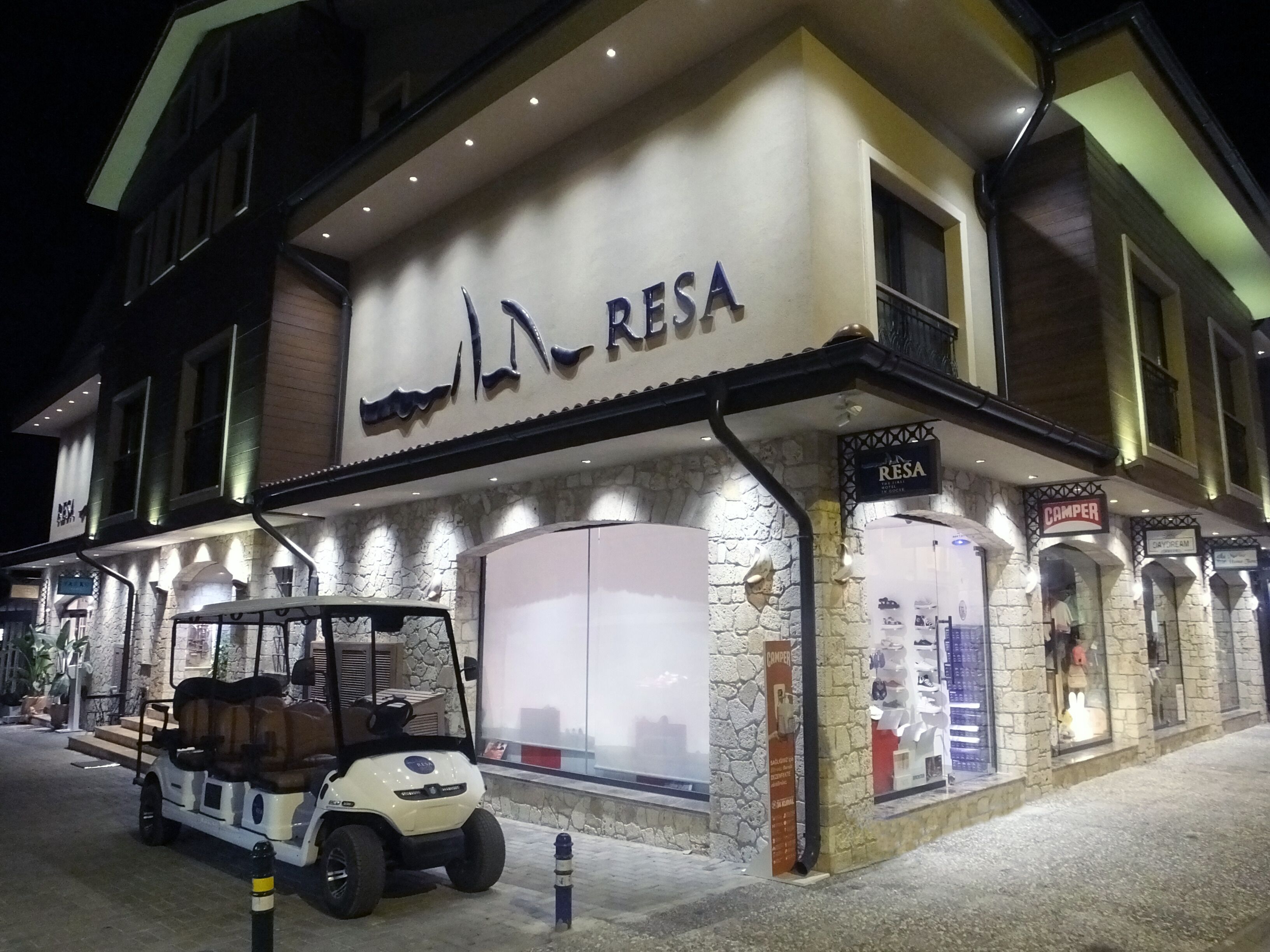 A building with a sign reading "RESA" and a golf cart parked in front.