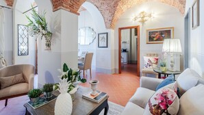 A spacious living room with a brick ceiling, a dining area with a view, and a kitchen in the background.