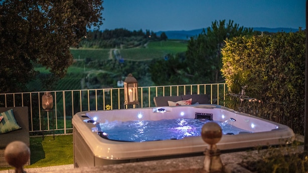 A hot tub with a view of a countryside landscape.