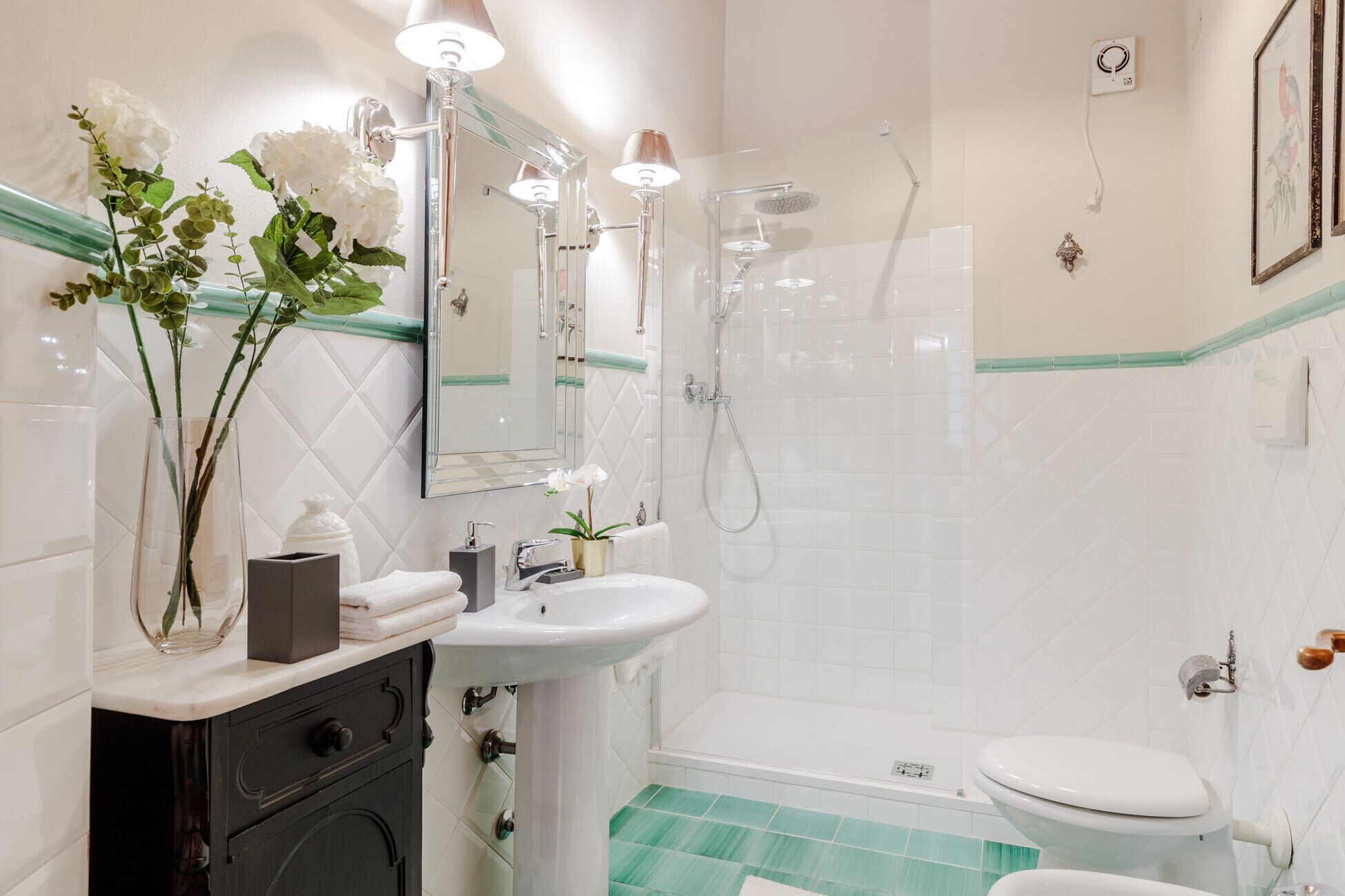 A modern bathroom with a glass shower enclosure, a white sink, and a toilet.