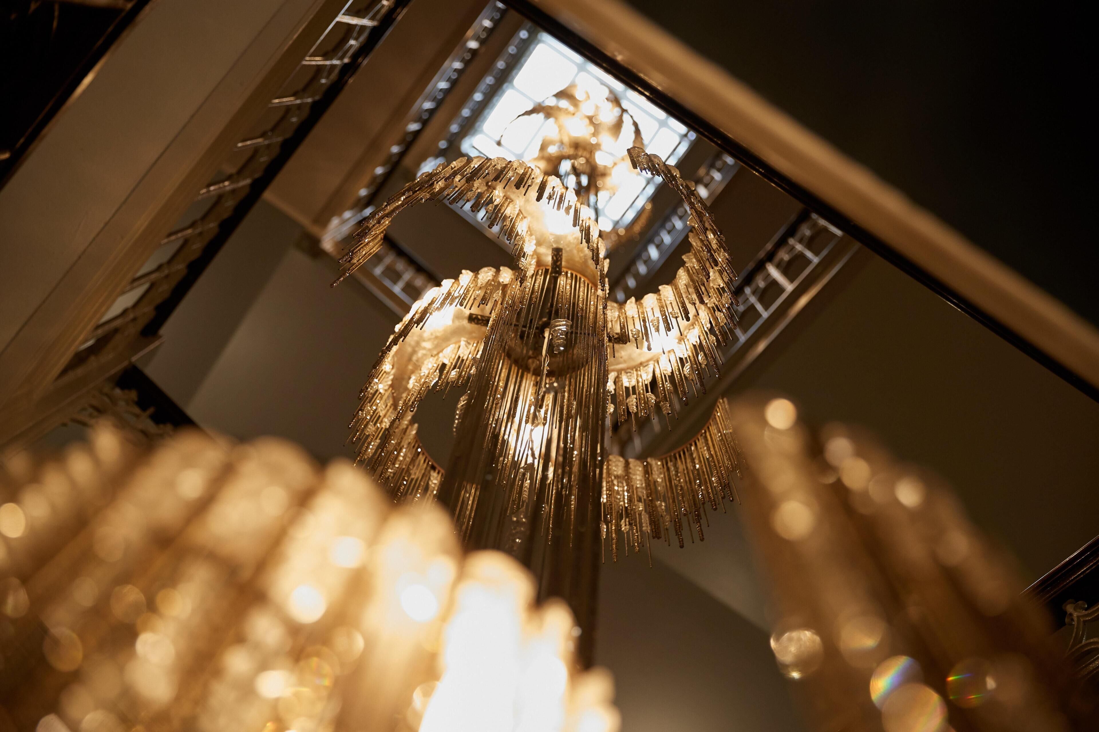 Een kroonluchter met meerdere lampen aan het plafond.